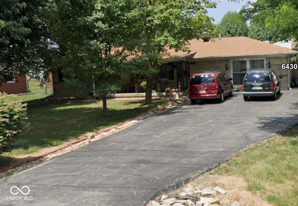 single story home featuring aphalt driveway and a front yard