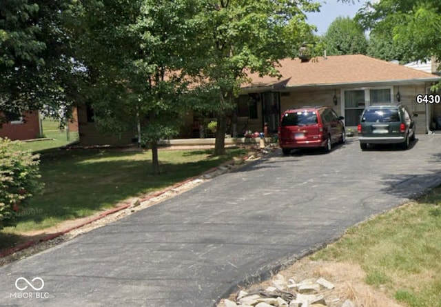 single story home featuring aphalt driveway and a front yard
