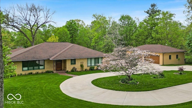 6465 Lawrence Dr, Indianapolis, IN 46226 - single story home with curved driveway, a front lawn, a garage, and brick siding