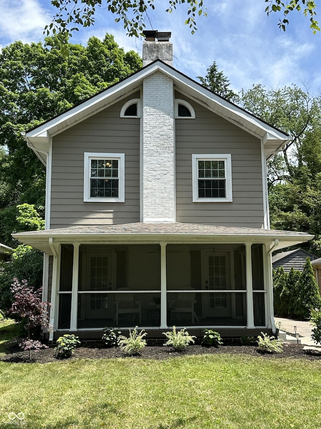 5829 Broadway St, Indianapolis, IN 46220 - view of front facade featuring a chimney, a front lawn, and a sunroom