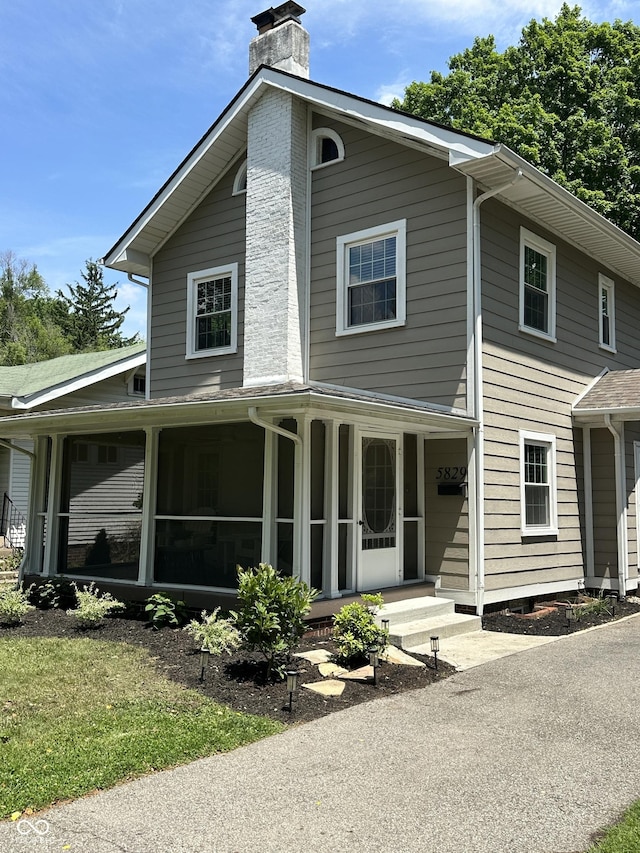 5829 Broadway St, Indianapolis, IN 46220 - view of front of property featuring a chimney and a sunroom