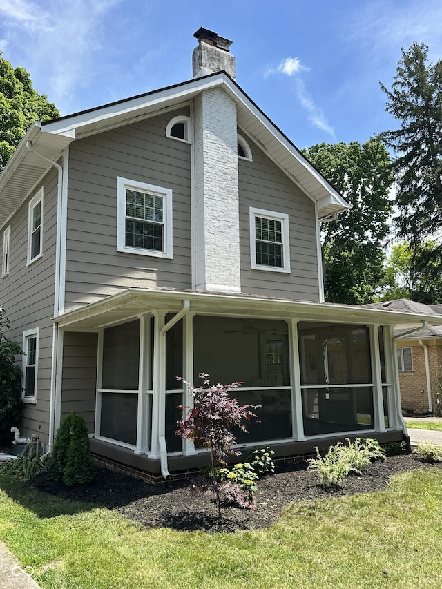 5829 Broadway St, Indianapolis, IN 46220 - view of side of property with a sunroom and a chimney