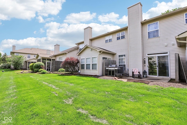 7045 Gavin Dr, Indianapolis, IN 46217 - back of property featuring a chimney, a lawn, and a patio area