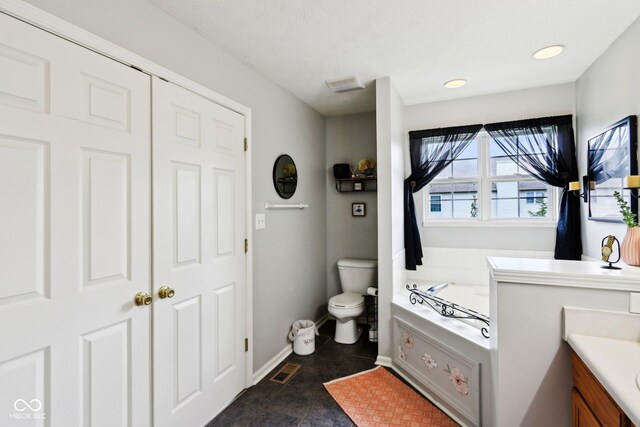 7045 Gavin Dr, Indianapolis, IN 46217 - bathroom with toilet, a garden tub, baseboards, and vanity