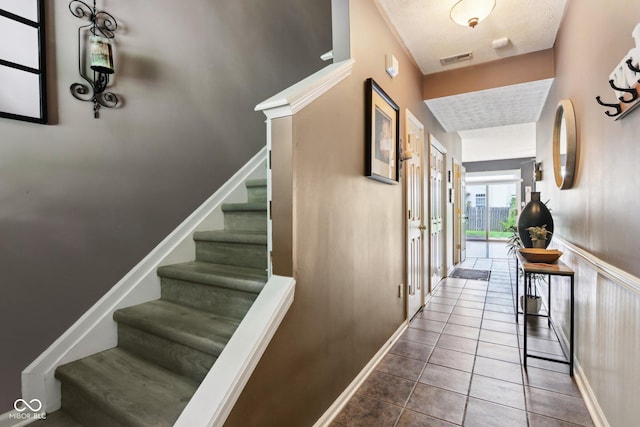 7045 Gavin Dr, Indianapolis, IN 46217 - staircase featuring tile patterned flooring, baseboards, and a textured ceiling