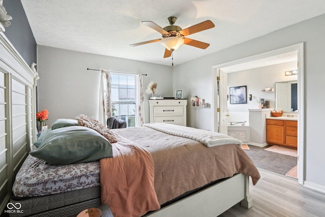 7045 Gavin Dr, Indianapolis, IN 46217 - bedroom featuring light wood-style floors, ensuite bath, ceiling fan, and baseboards