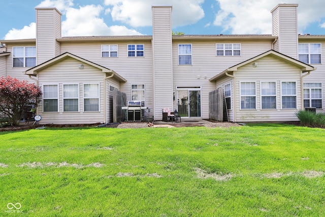 7045 Gavin Dr, Indianapolis, IN 46217 - rear view of property with a chimney, a lawn, and a patio area