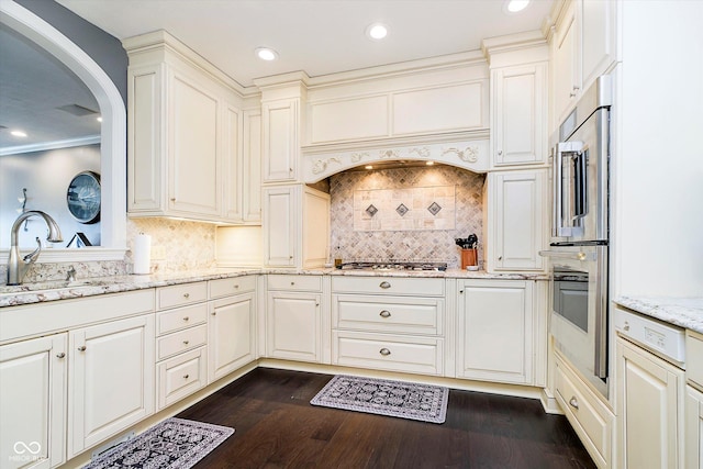 11319 Shoreview Ln, Indianapolis, IN 46236 - kitchen with a sink, stainless steel appliances, arched walkways, light stone countertops, and dark wood-style flooring