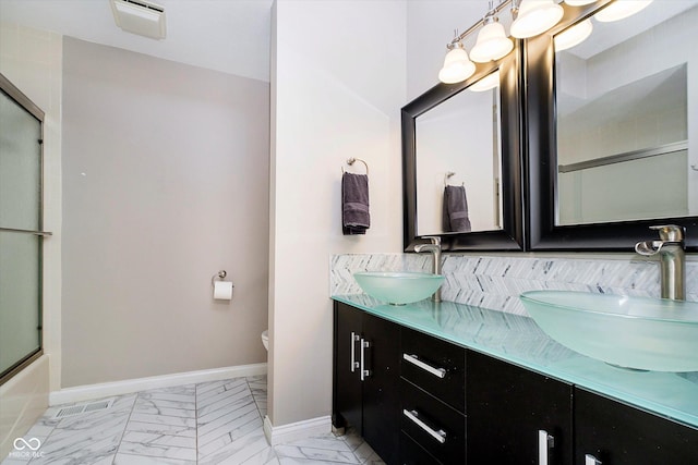 11319 Shoreview Ln, Indianapolis, IN 46236 - full bathroom with toilet, double vanity, marble look tiles, baseboards, and shower / bath combination with glass door