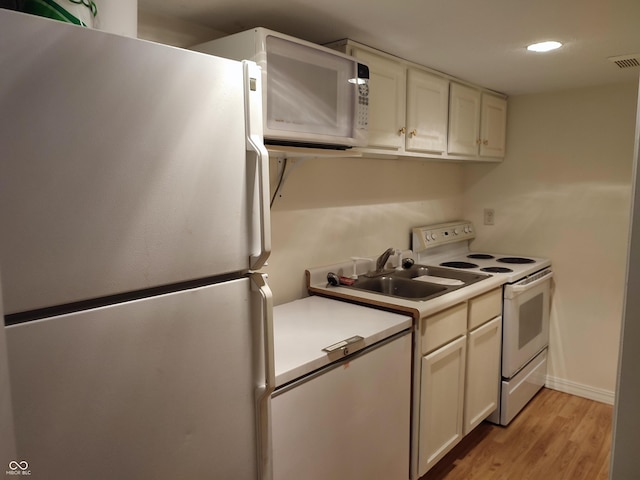 4719 Arabian Run, Indianapolis, IN 46228 - kitchen with white appliances, light wood-style floors, light countertops, a sink, and white cabinets