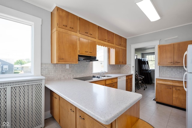 kitchen featuring white appliances, under cabinet range hood, light countertops, tasteful backsplash, and crown molding