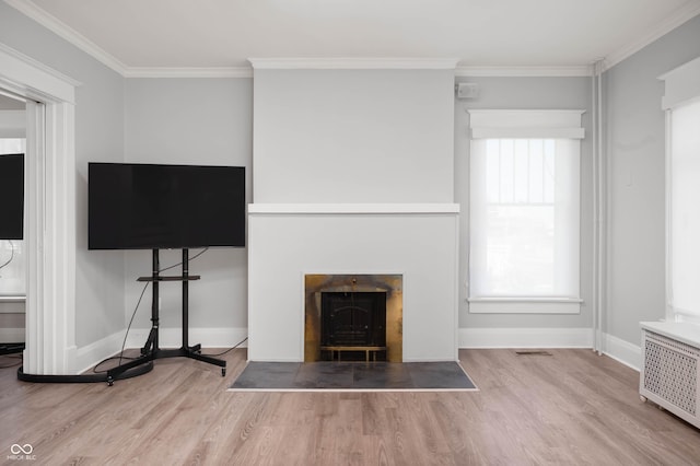 unfurnished living room featuring a fireplace with flush hearth, wood finished floors, crown molding, radiator heating unit, and baseboards