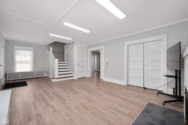 unfurnished living room with crown molding, wood finished floors, baseboards, and radiator
