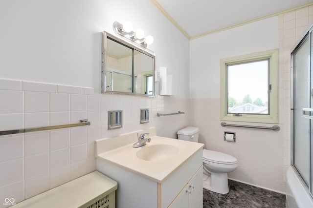 full bathroom featuring toilet, vanity, tile walls, crown molding, and a wainscoted wall