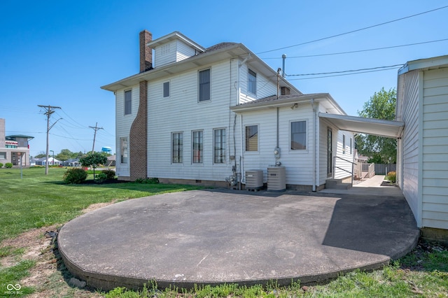 rear view of property with central AC unit, a chimney, and a yard