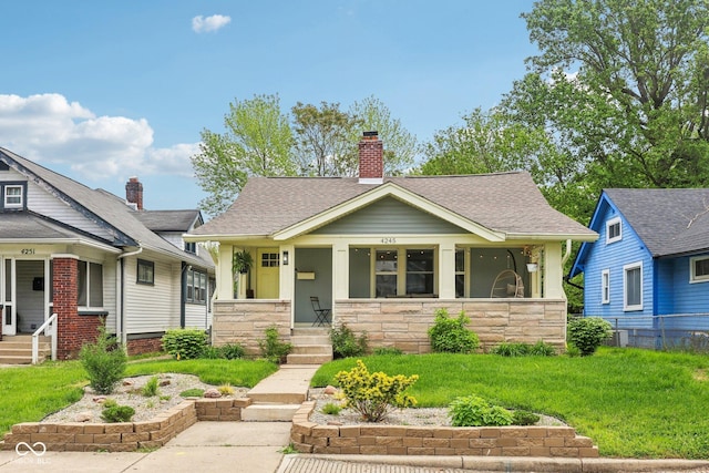 4245 Guilford Ave, Indianapolis, IN 46205 - view of front of house featuring stone siding, a porch, and a shingled roof