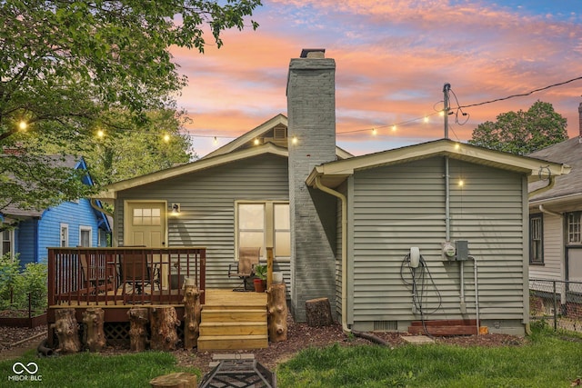 4245 Guilford Ave, Indianapolis, IN 46205 - back of house at dusk featuring a wooden deck, a chimney, and fence