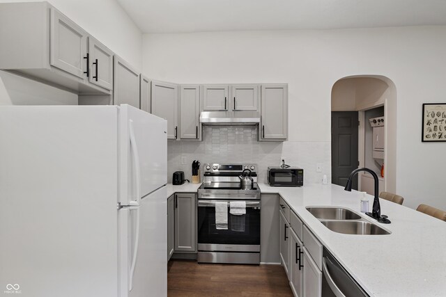 1728 N Delaware St, Indianapolis, IN 46202 - kitchen with stainless steel appliances, a sink, gray cabinetry, under cabinet range hood, and light countertops