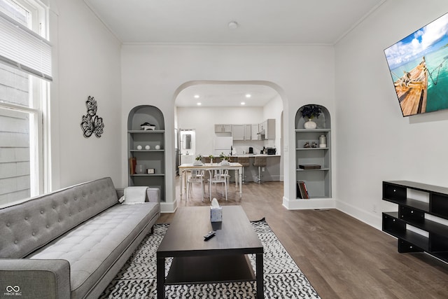 1728 N Delaware St, Indianapolis, IN 46202 - living room featuring arched walkways, built in shelves, wood finished floors, ornamental molding, and baseboards