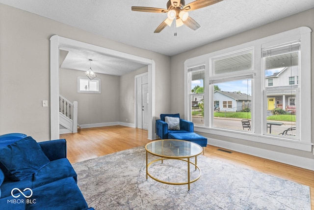 1505 Spann Ave, Indianapolis, IN 46203 - living room with wood finished floors, plenty of natural light, stairs, baseboards, and a textured ceiling