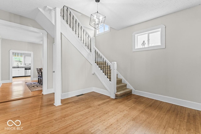1505 Spann Ave, Indianapolis, IN 46203 - stairway featuring hardwood / wood-style flooring, baseboards, and a chandelier