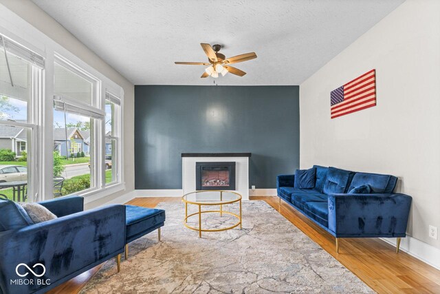 1505 Spann Ave, Indianapolis, IN 46203 - living room with a ceiling fan, wood finished floors, a glass covered fireplace, baseboards, and a textured ceiling