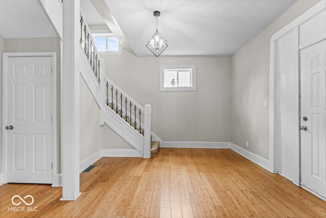 1505 Spann Ave, Indianapolis, IN 46203 - foyer entrance featuring a chandelier, stairs, light wood-type flooring, and baseboards