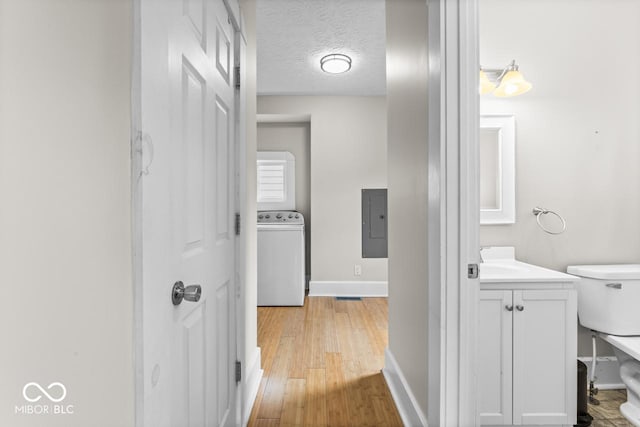 1505 Spann Ave, Indianapolis, IN 46203 - half bathroom featuring washer / dryer, electric panel, baseboards, wood finished floors, and vanity