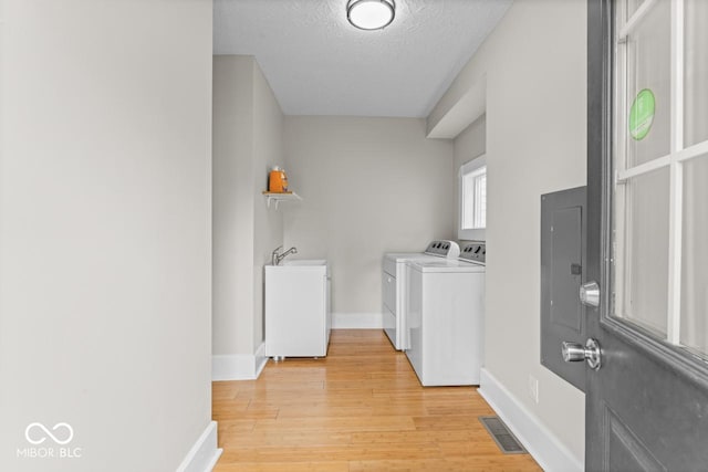 1505 Spann Ave, Indianapolis, IN 46203 - washroom featuring washer and clothes dryer, light wood-style flooring, baseboards, and a textured ceiling