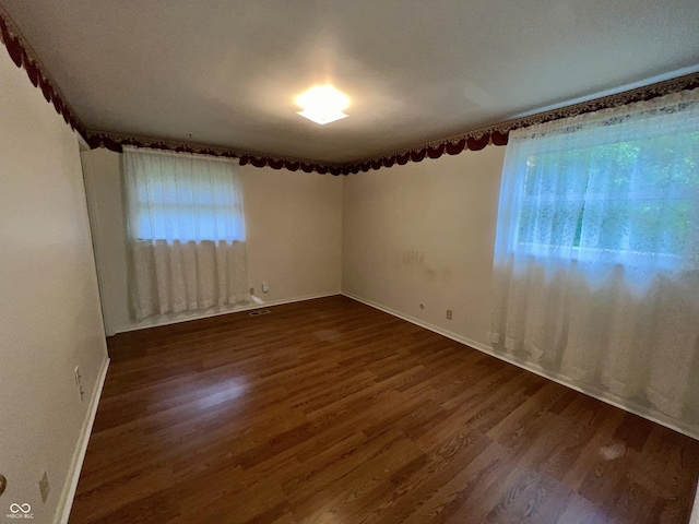 1949 Shenandoah Pl, Indianapolis, IN 46229 - empty room with plenty of natural light, dark wood-style floors, and baseboards