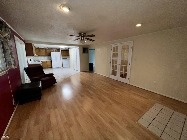 1949 Shenandoah Pl, Indianapolis, IN 46229 - living area with separate washer and dryer, french doors, a ceiling fan, light wood finished floors, and baseboards