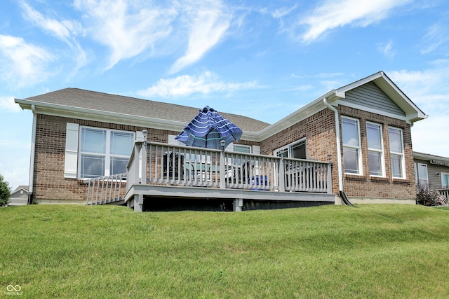 rear view of property with a yard, brick siding, and a deck