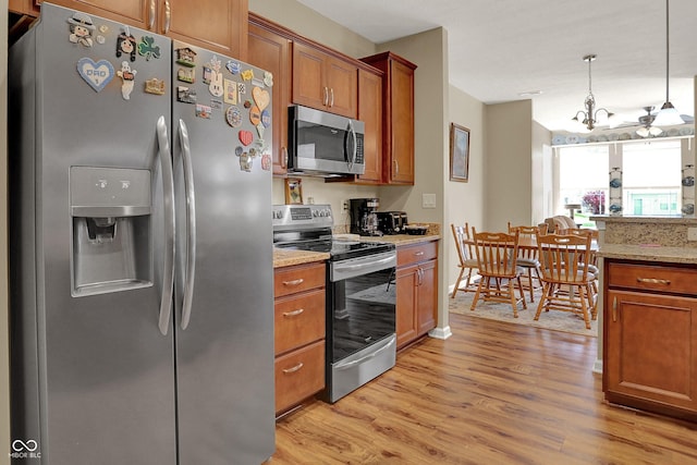 kitchen with brown cabinetry, light wood-style floors, and stainless steel appliances