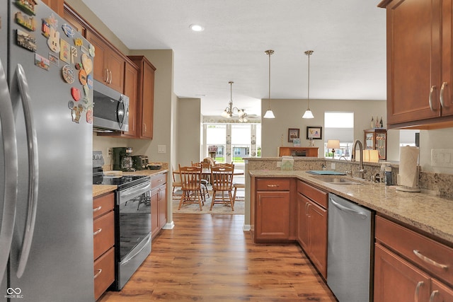 kitchen with stainless steel appliances, a peninsula, a sink, and plenty of natural light