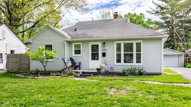 view of front of property with an outbuilding, a chimney, a garage, and a shingled roof