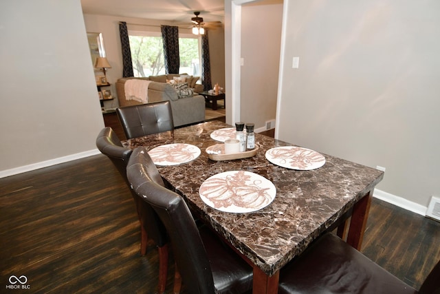 dining area featuring baseboards, a ceiling fan, and dark wood-style floors