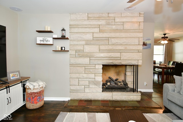 living area with a fireplace, baseboards, a ceiling fan, and wood finished floors
