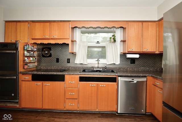 kitchen with dark countertops, tasteful backsplash, black appliances, and a sink