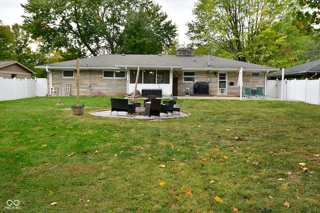 rear view of property with stone siding, a patio, a fenced backyard, and an outdoor living space
