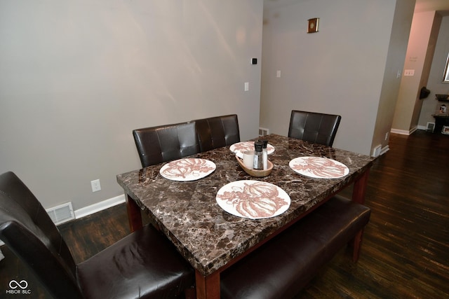 dining room featuring dark wood-type flooring, baseboards, and visible vents