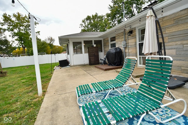 view of patio featuring a grill and fence