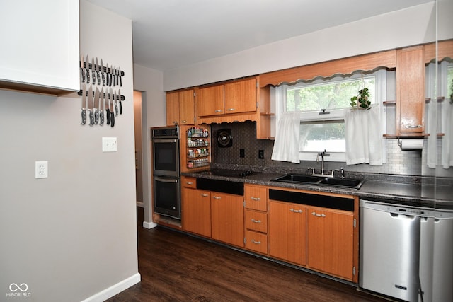 kitchen featuring dark countertops, decorative backsplash, a sink, and dishwasher
