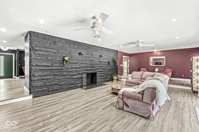 living area with ceiling fan, recessed lighting, wood finished floors, an accent wall, and baseboards