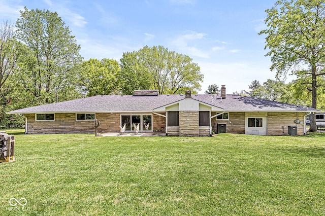 rear view of house with a chimney, stone siding, a yard, and a patio