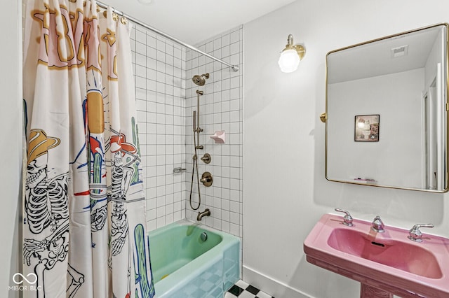 bathroom featuring shower / bathtub combination with curtain, a sink, and baseboards