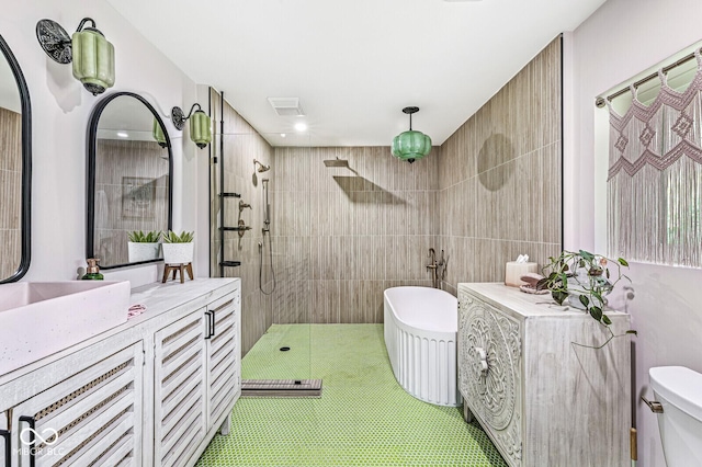 bathroom with a walk in shower, a freestanding tub, vanity, and toilet