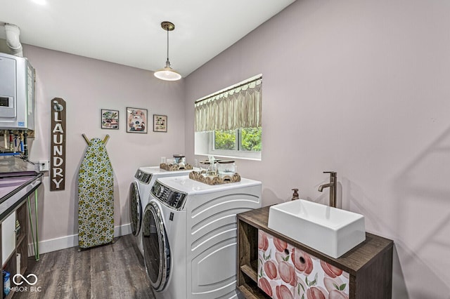 laundry room featuring washing machine and dryer, dark wood-style floors, and baseboards