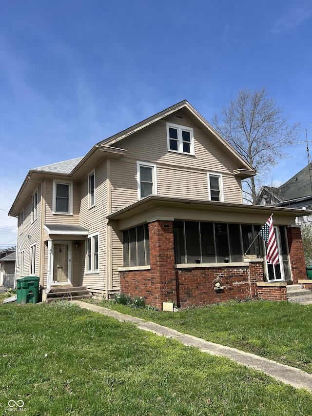 view of front facade featuring brick siding and a front lawn