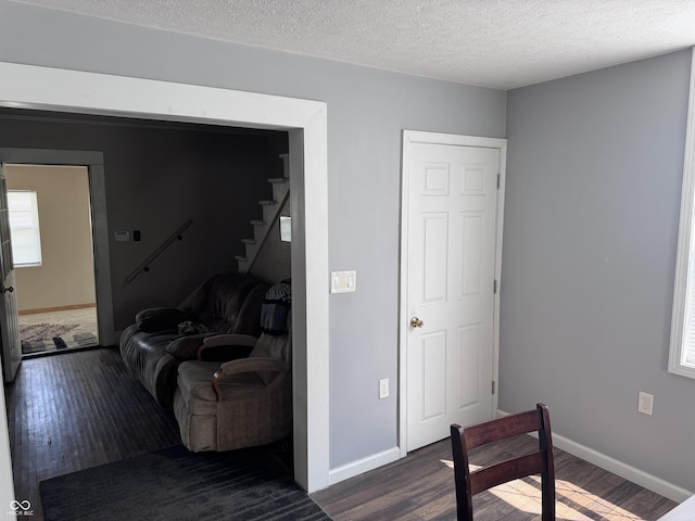bedroom featuring dark wood-style flooring, baseboards, and a textured ceiling
