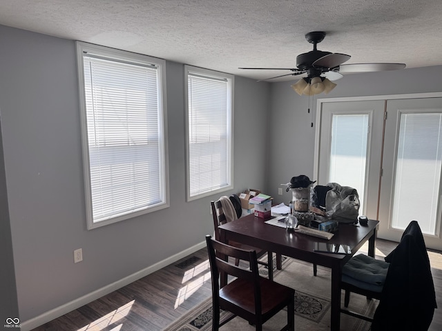 dining space featuring wood finished floors, a textured ceiling, ceiling fan, and baseboards